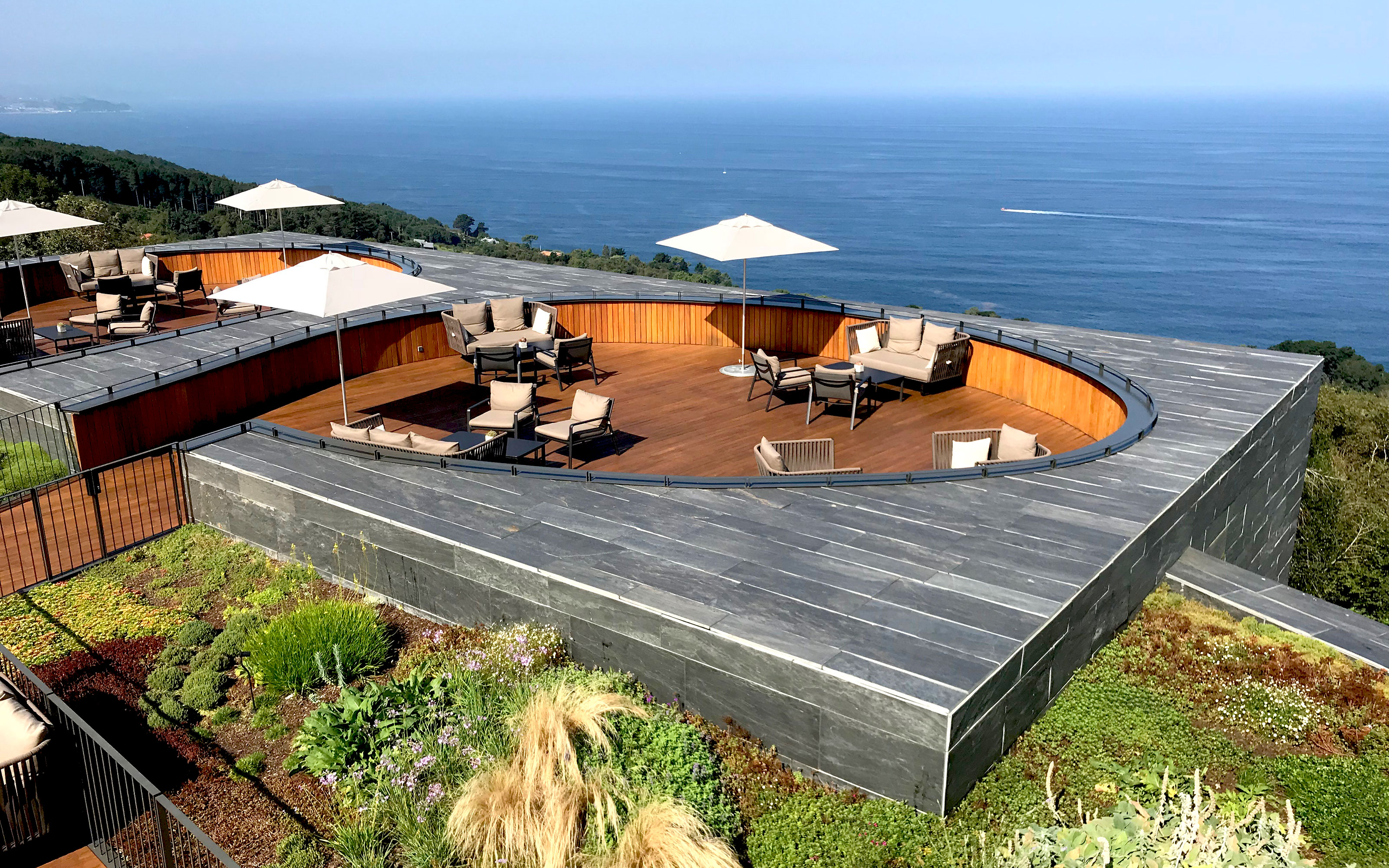 The seating area offers a wonderful view over the sea. Bird's eye view onto terraces surrounded by vegetation and a view onto the ocean